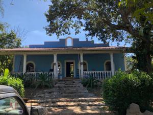 una casa azul con escaleras que conducen a ella en Casa de campo Hacienda Multunkú Minerva, en Seyé