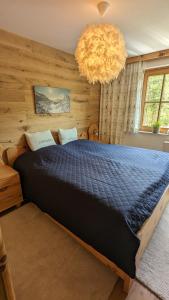 a bedroom with a large bed with a chandelier at Alpenchalet im Steirischen Salzkammergut in Tauplitz