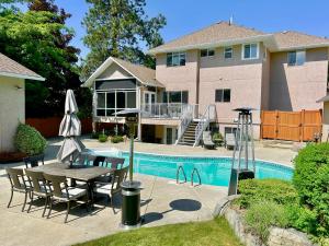 a house with a table and chairs next to a pool at Vintner's Nook B&B in Kelowna