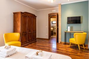 Zimmer mit einem Bett, 2 Stühlen und einem TV in der Unterkunft La Ginestra in Fiore Camere in Sirolo