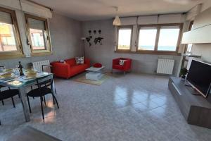 a living room with a red couch and a table at Prospettiva Mare Apartament in Piombino