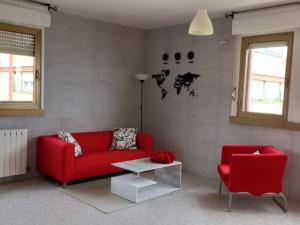 a living room with a red couch and a red chair at Prospettiva Mare Apartament in Piombino