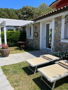 a patio with two picnic tables in front of a house at Casa Vacanze Randelli in Ameglia