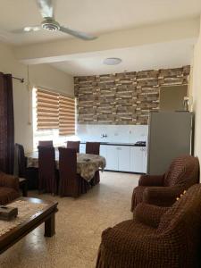 a living room with a table and chairs and a kitchen at Downtown Apartment in Beit Sahour