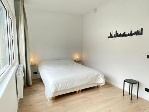una camera bianca con un letto e una finestra di #2800ourhome 201 a Mechelen