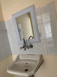 La salle de bains est pourvue d'un lavabo, d'un miroir et d'un robinet. dans l'établissement Downtown Apartment, à Bayt Sāḩūr