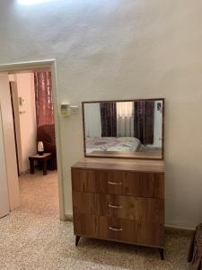 - une commode avec un miroir dans la chambre dans l'établissement Downtown Apartment, à Bayt Sāḩūr