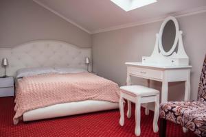 sypialnia z łóżkiem, toaletką i lustrem w obiekcie VENA Noclegi Restauracja Sala Bankietowa w mieście Malanów