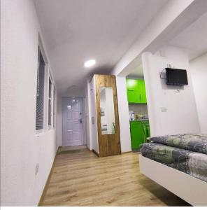 a room with a bed and a hallway with green cabinets at Maya's Apartments in Kruševo