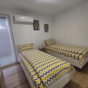 two beds sitting next to each other in a bedroom at Maya's Apartments in Kruševo