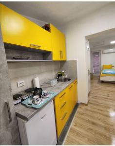 a kitchen with yellow cabinets and a counter top at Maya's Apartments in Kruševo