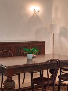 a dining room table with chairs and a plant on it at L'Artist Casa Micallef in Valletta