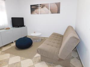 a living room with a couch and a tv at Apartment Stella in Koper