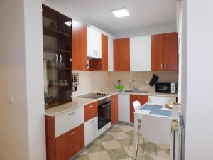 a kitchen with brown and white cabinets and a table at Apartment Stella in Koper