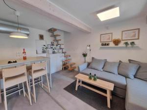 a living room and kitchen with a couch and a table at Várta-Lak Panoráma Présház Vendégház in Bakonycsernye