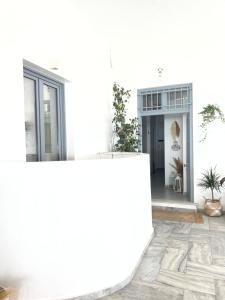 un edificio blanco con plantas en un patio en Kirki Rooms by the sea en Parikia