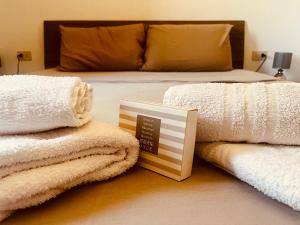 a bedroom with a bed with towels and a book at Lucia House in Santa Lucia