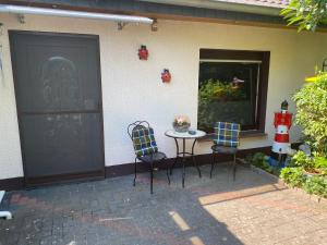 een patio met een tafel en stoelen naast een deur bij Ferienwohnung Gartenblick in Nordenham