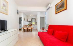 a living room with a red couch and a tv at Amazing Apartment In Pinezici With 2 Bedrooms And Wifi in Pinezici