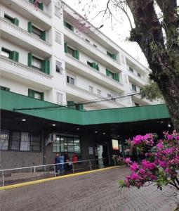 a large white building with people standing outside of it at Apartamento Bourbon 111 in Porto Alegre +14 photos