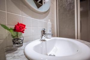 un lavabo con una rosa roja en un jarrón en Santa Fiora Ospitalità Diffusa - Il Nido, en Santa Fiora