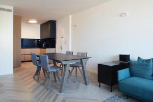 - une salle à manger avec une table, des chaises et un canapé dans l'établissement Luxury SeaSide DeShalit Square, à Herzliya