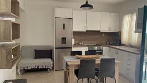 a kitchen with a table and chairs and a kitchen with white cabinets at Asterias Studios in Adamantas