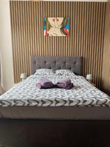 łóżko z dwoma poduszkami i muszką w obiekcie Wczasowa 3 w Warszawie