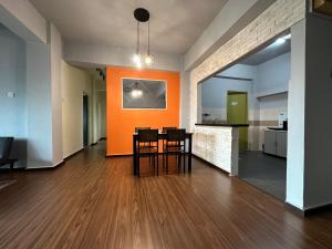 Una sala de estar vacía con una mesa y una pared naranja. en Family apartment in Tawau Town, en Tawau