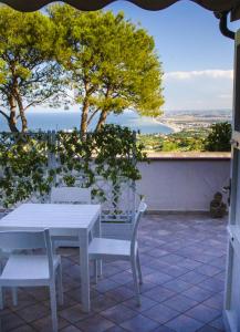einen weißen Tisch und Stühle auf einer Terrasse mit Aussicht in der Unterkunft La Ginestra in Fiore Camere in Sirolo