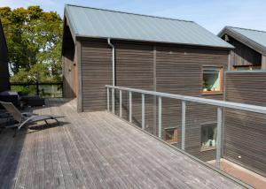 a large wooden deck with a house at Halltorp Townhouse in Borgholm