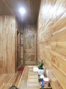 een kamer met een houten muur en een deur bij Tuyet's hostel in Ninh Binh