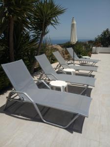 een rij chaise loungestoelen op een patio bij Villa Iremia in Chrani