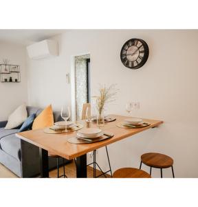 a dining room table with chairs and a clock on the wall at #L'Estere WiFi-Netflix-Clim in Eauze