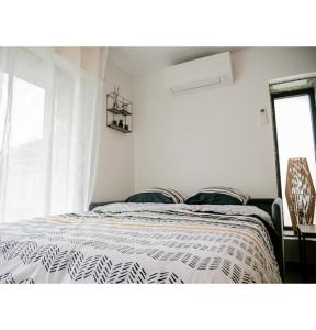 - une chambre avec un lit et une couette noire et blanche dans l'établissement #L'Estere WiFi-Netflix-Clim, à Eauze