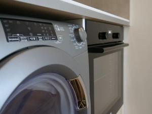 a washing machine with its door open next to a microwave at #L'Estere WiFi-Netflix-Clim in Eauze