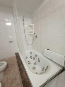 La salle de bains blanche est pourvue d'une baignoire et de toilettes. dans l'établissement Casa vacanze completa di tutto e anche di più, à Livourne