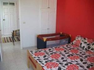 um quarto com uma cama com uma parede vermelha em Mahdia zone Touristique em Mahdia