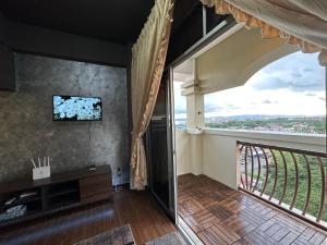 a living room with a large window and a tv at Family apartment in Tawau city centre in Tawau