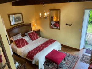 a bedroom with a bed with red pillows and a mirror at Manoir de Kerliviry in Cléder