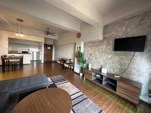 Family apartment in Tawau city centre في تاواو: غرفة معيشة مع أريكة وتلفزيون بشاشة مسطحة