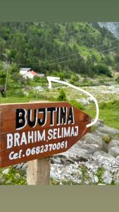 un panneau sur un pôle avec une montagne en arrière-plan dans l'établissement Bujtina Brahim Selimaj, à Valbonë