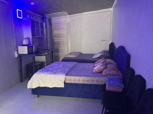- une chambre avec un lit, un bureau et des lumières violettes dans l'établissement Central rooms, à Chişinău