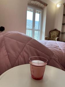 a cup sitting on top of a table in front of a bed at FONTANA’S HOUSE RELAX 13A in Valbravenna