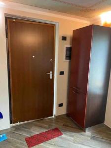 a large brown door in a room with a red rug at FONTANA’S HOUSE RELAX 13A in Valbravenna