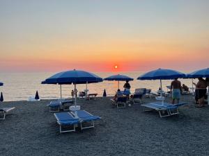 a group of beach chairs and umbrellas on the beach at Lido Tirreno beach in Campora San Giovanni
