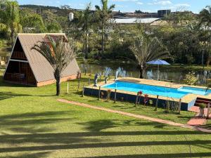 a swimming pool in a park next to a lake at Pousada dos Azevedo in Cláudio