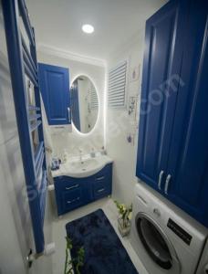 a bathroom with blue cabinets and a sink and a mirror at MAX 3+1 in Istanbul