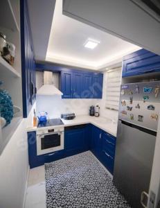 a kitchen with blue cabinets and a stove top oven at MAX 3+1 in Istanbul