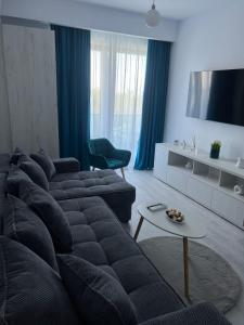 a living room with a couch and a tv at Apartament Hera Mamaia Nord in Năvodari